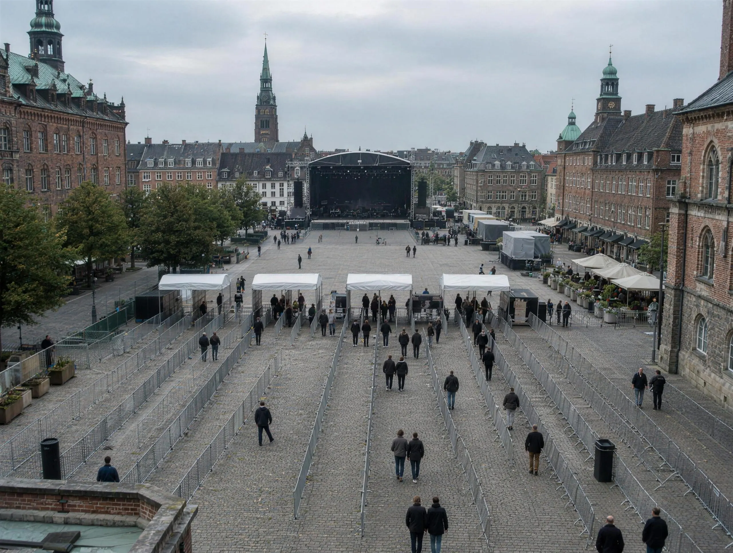 Byplads set fra oven før en koncert, med afspærringer der danner rækker mod indgangene